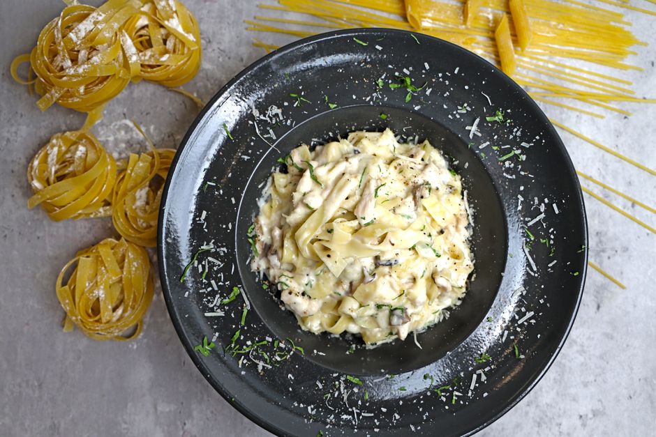 Delicious bowl of creamy fettuccine pasta topped with Parmesan cheese, perfect for a gourmet meal.